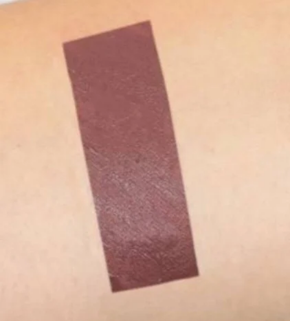 Lèvre avec lipstick liquide mat couleur prune foncé de 7 ml de la marque Chogan, application visible sur la photo.