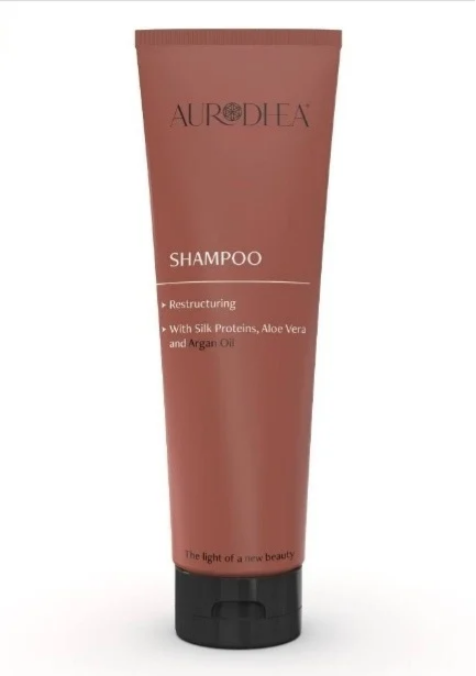 Shampoing revitalisant à l'argan pour cheveux, contenant des huiles nourrissantes, dans un flacon blanc avec étiquette.
